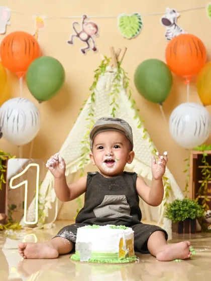 Hands up if you love cake! A joyful cake smash moment during a wild one's jungle-themed birthday.