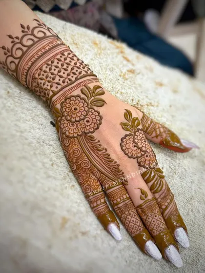 A beautiful floral henna design for any occasion. The delicate flowers and leaves create a soft and romantic look on the back of the hand.