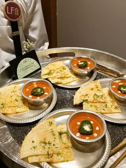 Our server presenting a tray of mini naan with a creamy tomato soup at a Diwali party. This is a comforting and elegant way to serve a classic combination that guests love.