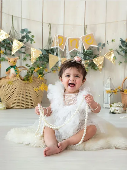 Capturing that big, gummy smile is what milestone sessions are for. This little one is celebrating her ability to sit up, and her happy expression shows how much fun we have in the studio.