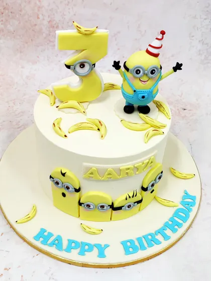 We celebrate with a dose of fun and mischief with this Minions birthday cake. A cheerful Minion in a party hat stands atop a cake decorated with his favorite snack, bananas, creating a playful and sunny design that is sure to make everyone smile.
