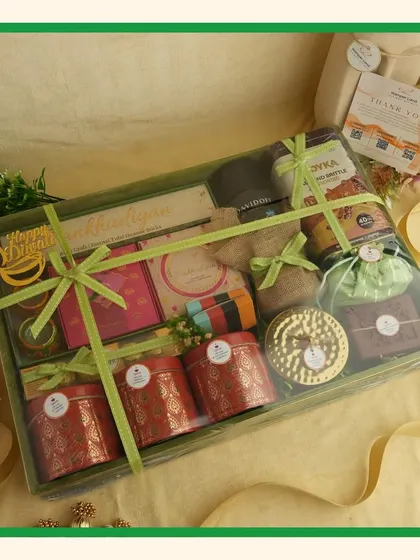 The fully packed and wrapped green hamper, tied with multiple ribbons to secure the items and add a decorative touch.