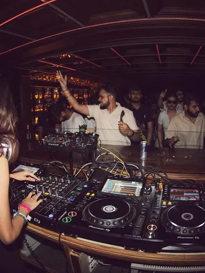 A fisheye lens captures the energy of the room, showing me at the decks and the crowd with their hands up.