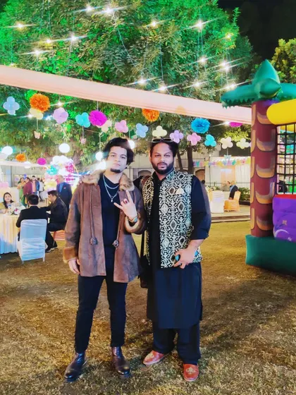 With a fellow musician at an outdoor event. It's great to connect with other artists during shows.