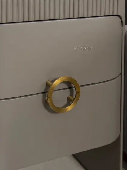 A detail of the Greco Side Table's hardware. The brushed gold circular pull is both functional and a beautiful design element, complementing the bed's metallic accents for a cohesive look.