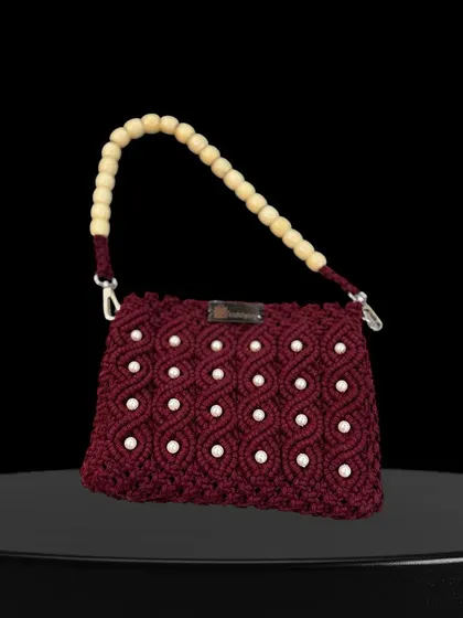 A stunning maroon handbag with pearl work and a wooden bead handle. This is a true statement piece for any celebration.