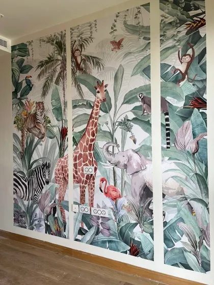 Go wild with your walls. This jungle-themed wallpaper, featuring giraffes, elephants, and monkeys, turns a simple wall into a vibrant safari scene, perfect for a child's room or a playful feature wall.
