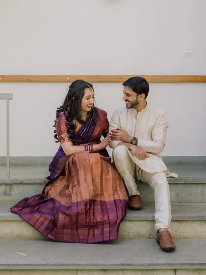 A candid shot of a couple sharing a happy moment on the steps of a modern resort.