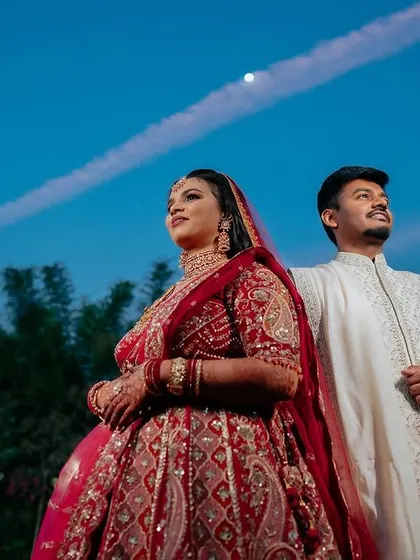 A regal bride in her magnificent red lehenga. We capture the grandeur of the bridal attire, creating portraits that are both powerful and elegant.
