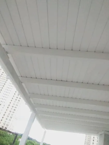 A view from below of the clean, white slatted ceiling of the European-style pergola. It gives the space a bright and airy feel while providing full coverage from the sun.