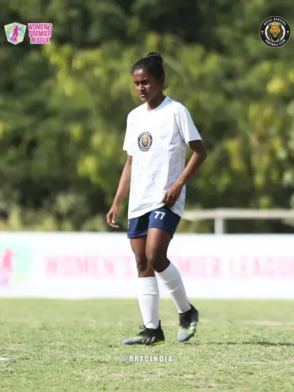 A player stands ready on the pitch, focused and waiting for the play to develop during a Women's Premier League game.
