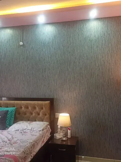 This textured wallpaper has a vertical grain pattern, which can help make a room with a low ceiling feel taller. The neutral grey color is versatile and calming for a bedroom.