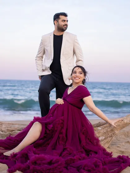 A stylish pose on the beach, showcasing the beautiful flow of the gown and the confident posture of the parents-to-be.