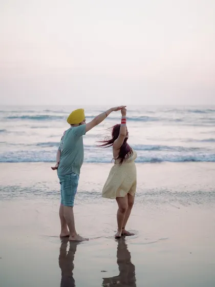 A playful dance on the beach at sunset. The silhouette against the water and the movement in the bride's hair create a beautiful, dynamic, and romantic photograph.