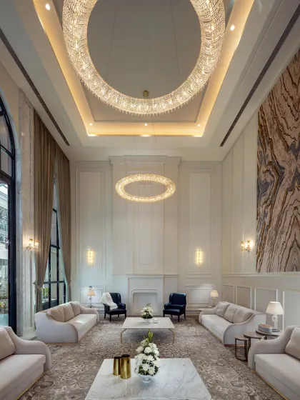 Another angle of the grand living room, showcasing the impressive scale and meticulous detail. The large art piece and fireplace serve as focal points, anchoring the sophisticated and comfortable seating arrangement.