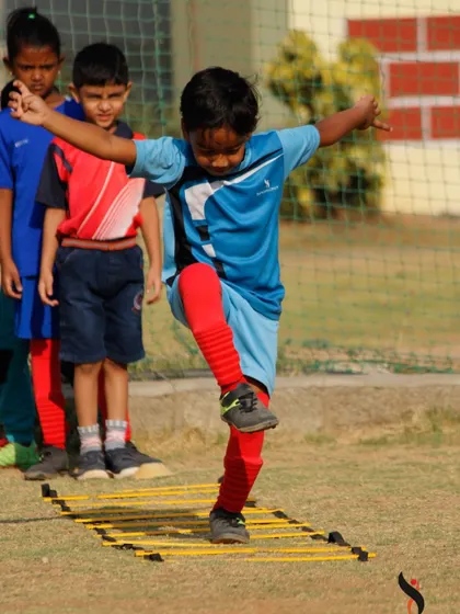 A player demonstrates excellent balance and coordination while navigating the agility ladder during a summer camp session.