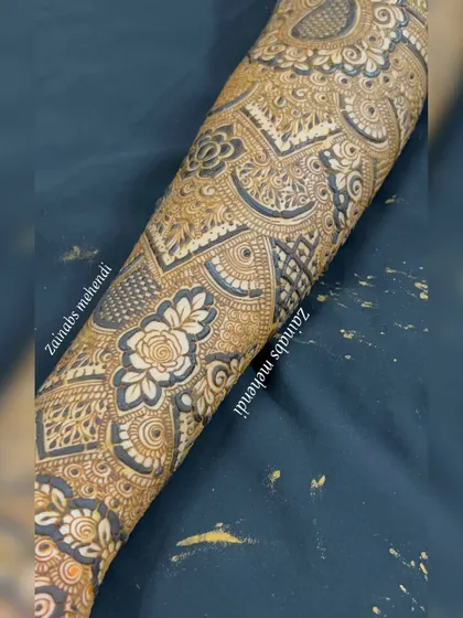 A detailed shot of the forearm portion of Musfira's bridal henna, highlighting the intricate rose and geometric work.