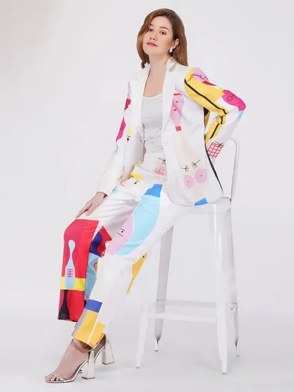 A model seated in a vibrant pantsuit, demonstrating a different pose for the same product to give customers a comprehensive view.