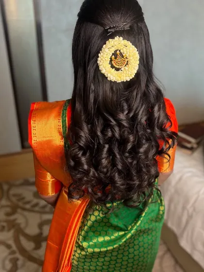 Neatly done hair and neatly arranged flowers make for a perfect hairstyle. This half-up style with soft curls is both elegant and timeless.