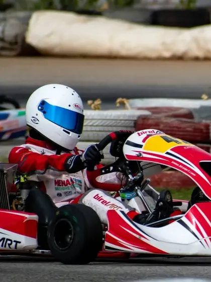 Driver in kart number 42 navigating a corner, with another competitor in the background. Our driver coaching focuses on maintaining composure and precision during close-quarters racing.