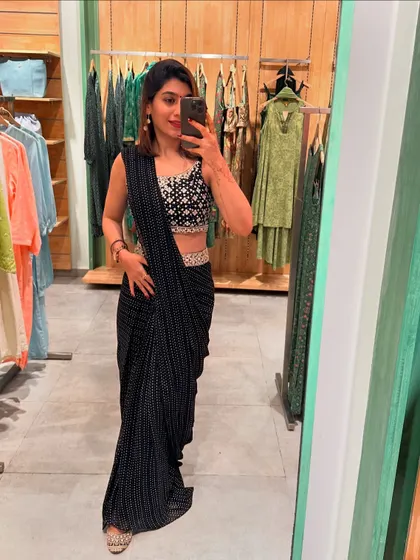 A full-length view of the black pre-draped saree with an embellished blouse. This is a perfect example of a glamorous yet effortless festive outfit.