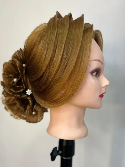 A side profile of the intricate floral hair bun, showing the detailed layering and shaping involved in its creation.