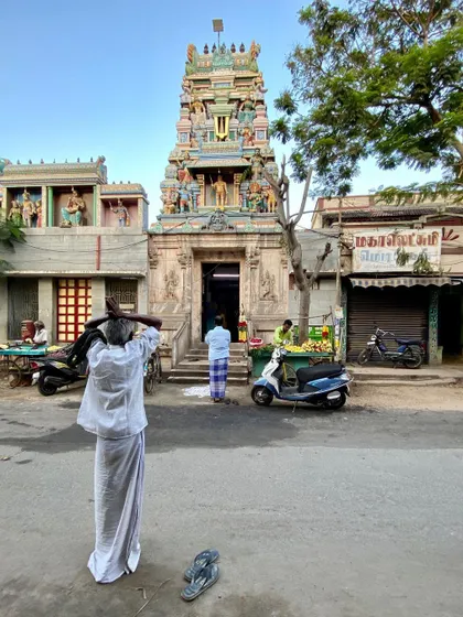 A devotee offers a prayer before a temple in Tiruchirappalli. The interplay of the sacred and the everyday is a defining characteristic of Indian urbanism that deeply influences my work.