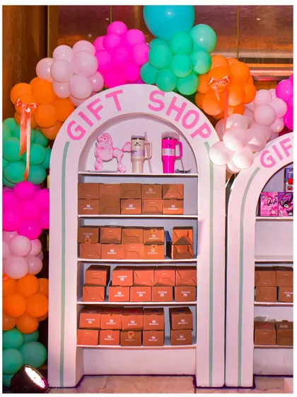 The 'Gift Shop' at the Parisian party, where guests could pick up their party favours. The setup is framed by a colourful balloon garland.