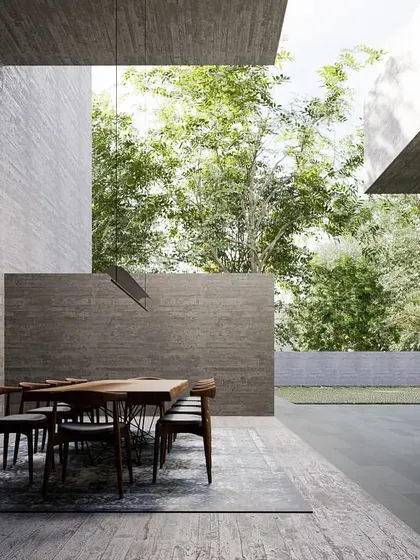 An interior render of the 'Tetris' house, looking out from a dining area defined by massive concrete walls. The space feels both monumental and intimately connected to the garden.