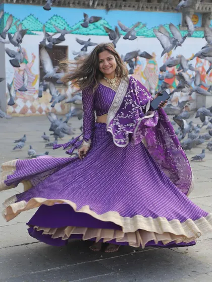 A joyful shot of the purple bandhani lehenga in motion. The traditional print combined with a modern silhouette makes it a versatile and beautiful choice.