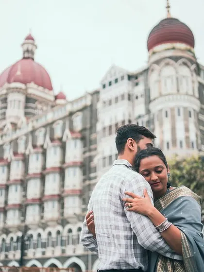 An intimate embrace with the iconic Taj Mahal Palace Hotel in the background. This photo blends a personal moment with a grand, historic Mumbai landmark.