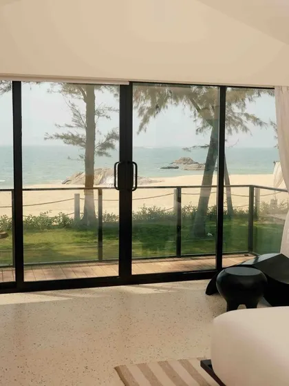 The bright and airy room at The Postcard Arabian Sea, with floor-to-ceiling windows that frame the perfect beach view.