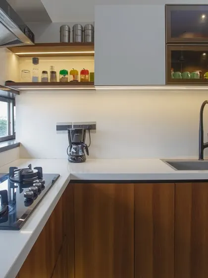 This stunning kitchen combines sleek aesthetics with practical elements. The rich walnut cabinetry offers ample storage, while the U-shaped layout maximizes counter space, perfect for a home chef.
