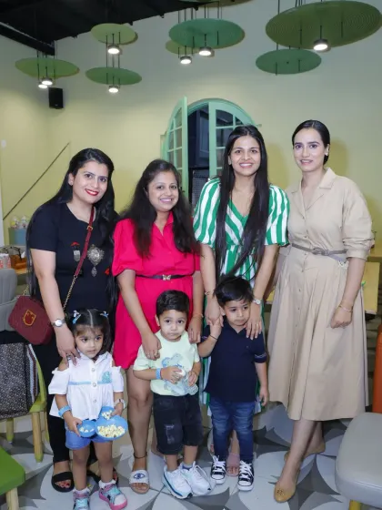 A group of mothers and their children posing together, enjoying a shared experience.