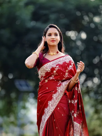 A lovely three-quarter portrait against a soft, out-of-focus background, making the red saree the star of the image.