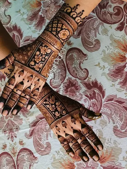Another angle of the heavy Indian back-hand design, showing the symmetry and detail in the floral and geometric bands.