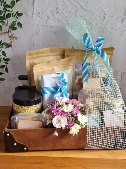A sophisticated brown suede box for Father's Day, combining our gourmet snacks with a beautiful fresh flower arrangement. It's a gift that's both delicious and elegant.