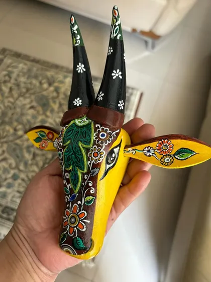 A yellow Nandi with one side decorated in a dark, dense Kalamkari-style floral pattern, creating a unique asymmetrical design.