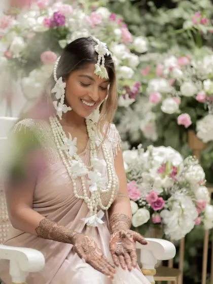 A beautiful, smiling bride adorned with floral jewelry and my intricate henna design. A picture of pure happiness.