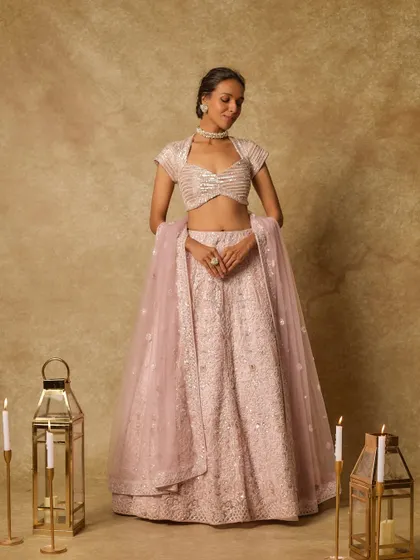 A client looks stunning in a dusty pink lehenga by Masumi Mewawalla, a piece that blends tradition with modern innovation.