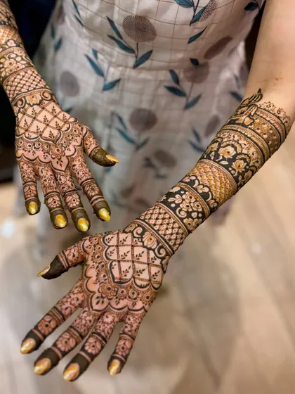 A beautiful bridal mehendi with a mix of floral bands and geometric grids.