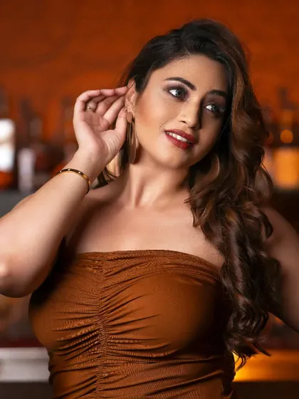 This image captures the elegant makeup and hairstyling in a moody, atmospheric setting. The soft curls and defined eyes create a look that is both glamorous and approachable.