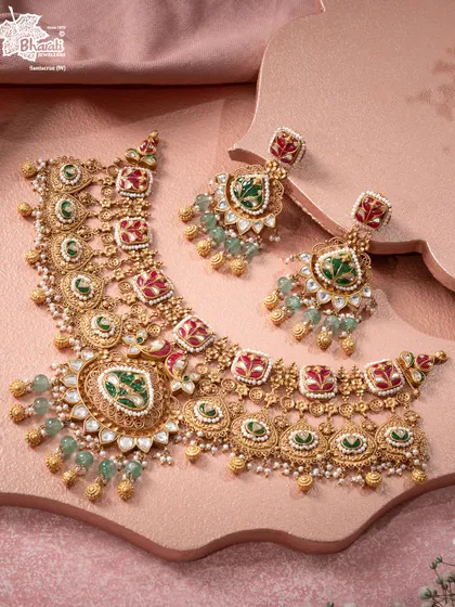 The Raagini Bikaneri Set is a lyrical tribute to Rajasthan’s cultural soul. This bridal necklace features vibrant red and green enamel strokes, intricate gold detailing, and gemstone accents, turning traditional artistry into a contemporary masterpiece.