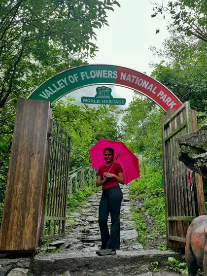 The official start of a floral paradise. A happy trekker at the entrance to the Valley of Flowers, a UNESCO World Heritage Site, ready to explore the meadows.