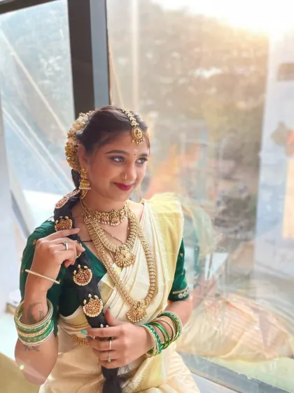 This image highlights the traditional braided hairstyle adorned with jasmine flowers and temple jewelry, a key component of the South Indian bridal look that I cover in my hairstyling modules.