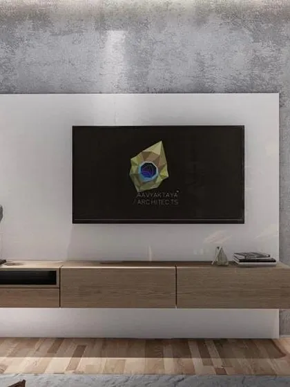 The media wall in the mother's bedroom, featuring a floating wooden console against a backdrop of concrete-textured and vertically fluted panels. The design is clean and minimalist, balancing different materials to create a calm and uncluttered space.