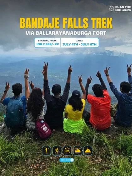 A group of friends with their arms up in victory, looking out at the incredible view from the Bandaje Falls trek.