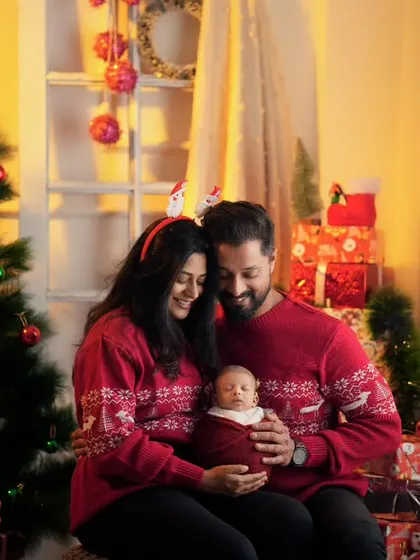 A cozy, festive family portrait with a newborn. I create warm and inviting indoor setups for special occasions like Christmas, capturing your family's first memories together.