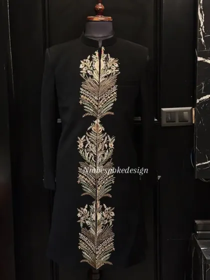 This black indowestern jacket is defined by a central panel of heavy, gold and silver feather-like embroidery, creating a regal and commanding presence.