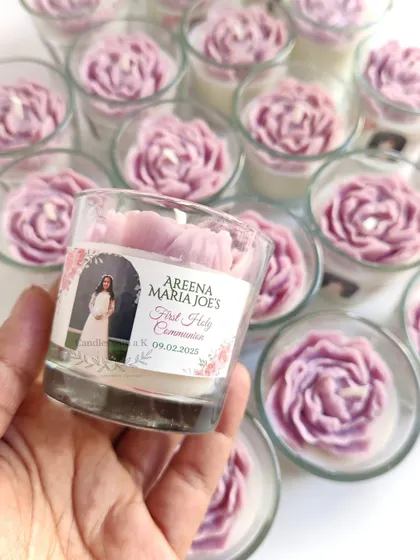 A hand holding one of the personalized peony candles, highlighting the custom photo and text on the sticker.